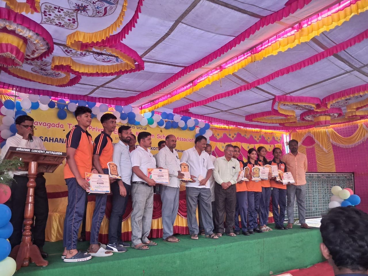Students receiving awards on stage at a taluk school event
